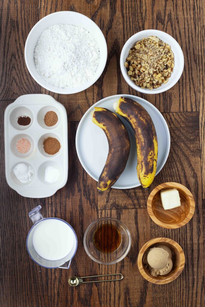 Ingredients for banana cupcakes on a wooden counter. 