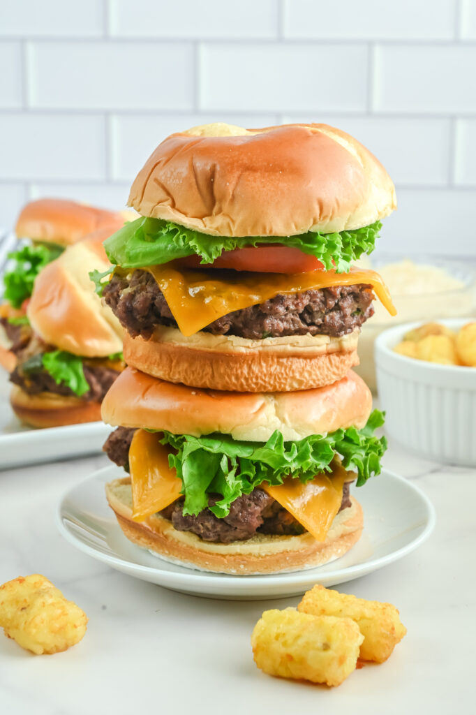 Stacked burgers on a white plate. 