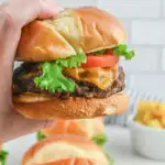 Holding a burger with a hand.