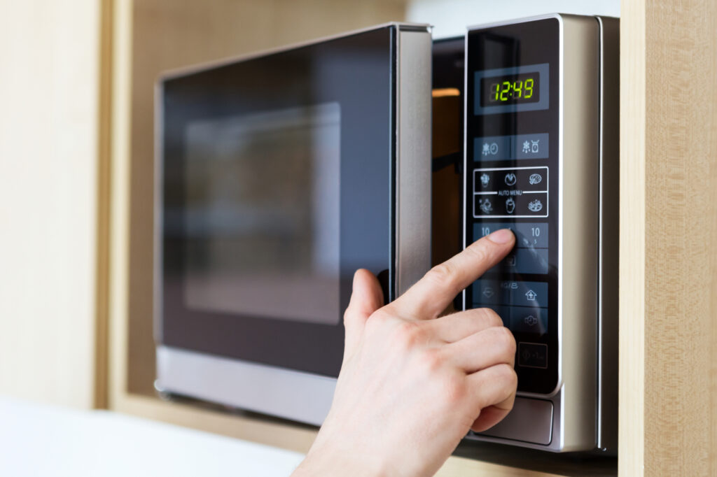 pushing buttons on a microwave