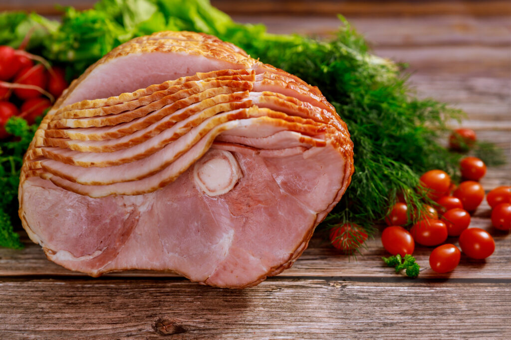 Spiral sliced hickory smoked ham with fresh herb and tomatoes.