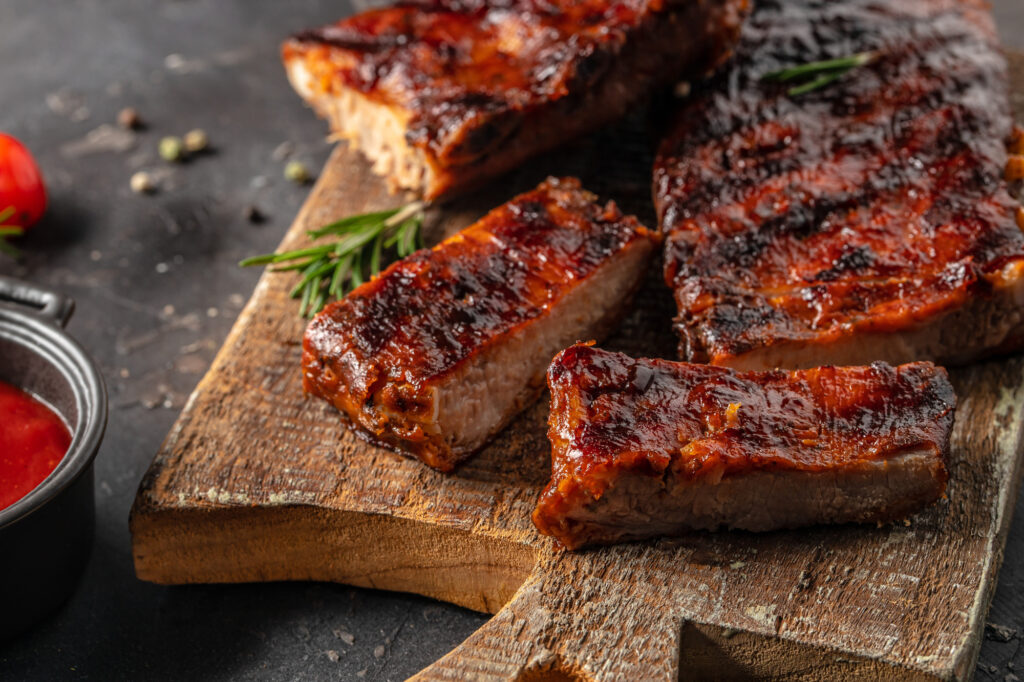 Barbecue chuck beef ribs with hot rub sliced on a wooden cutting board, Food recipe background. Close up,