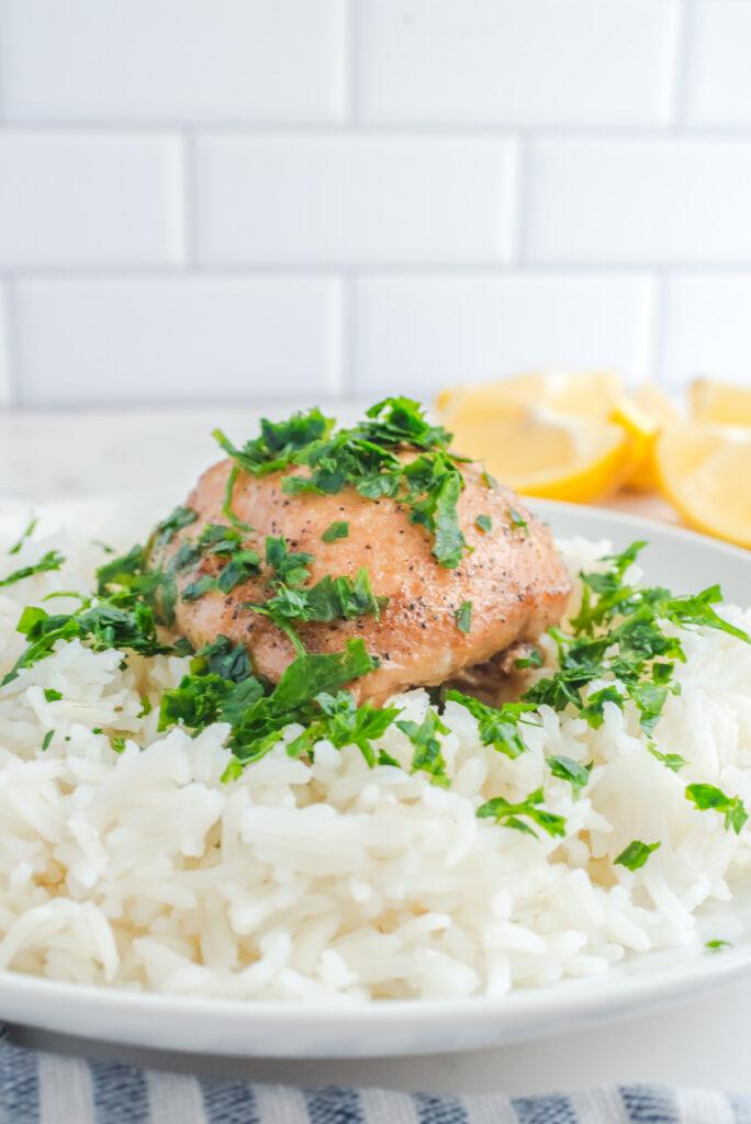 chicken thighs on a plate with white rice. 