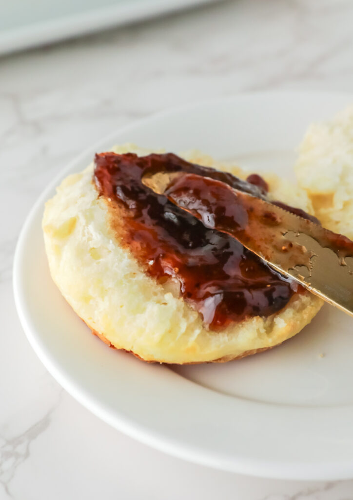 Spreading jelly on a biscuit. 